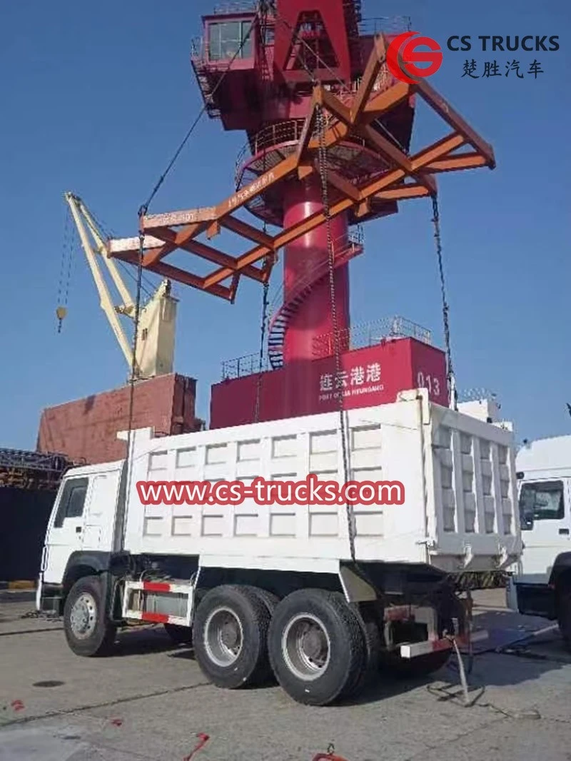 Dump truck loading on board for shipment Dump truck loading on board for shipment